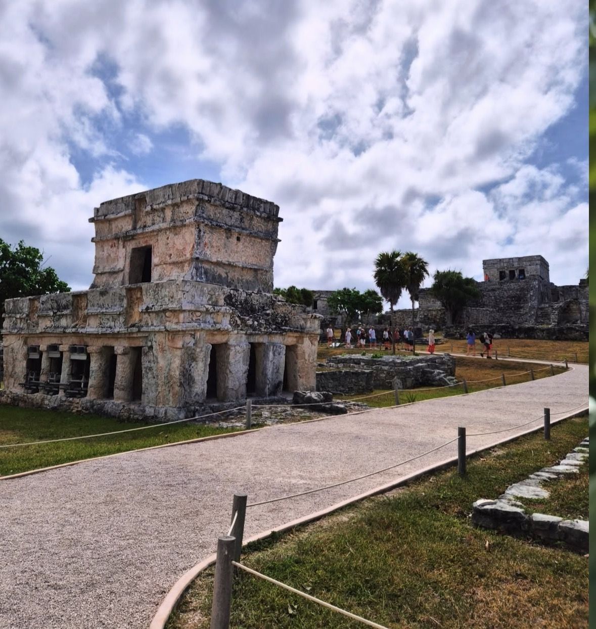 Licensed tour guide explaining Maya carvings to visitors at Tulum Ruins archaeological site